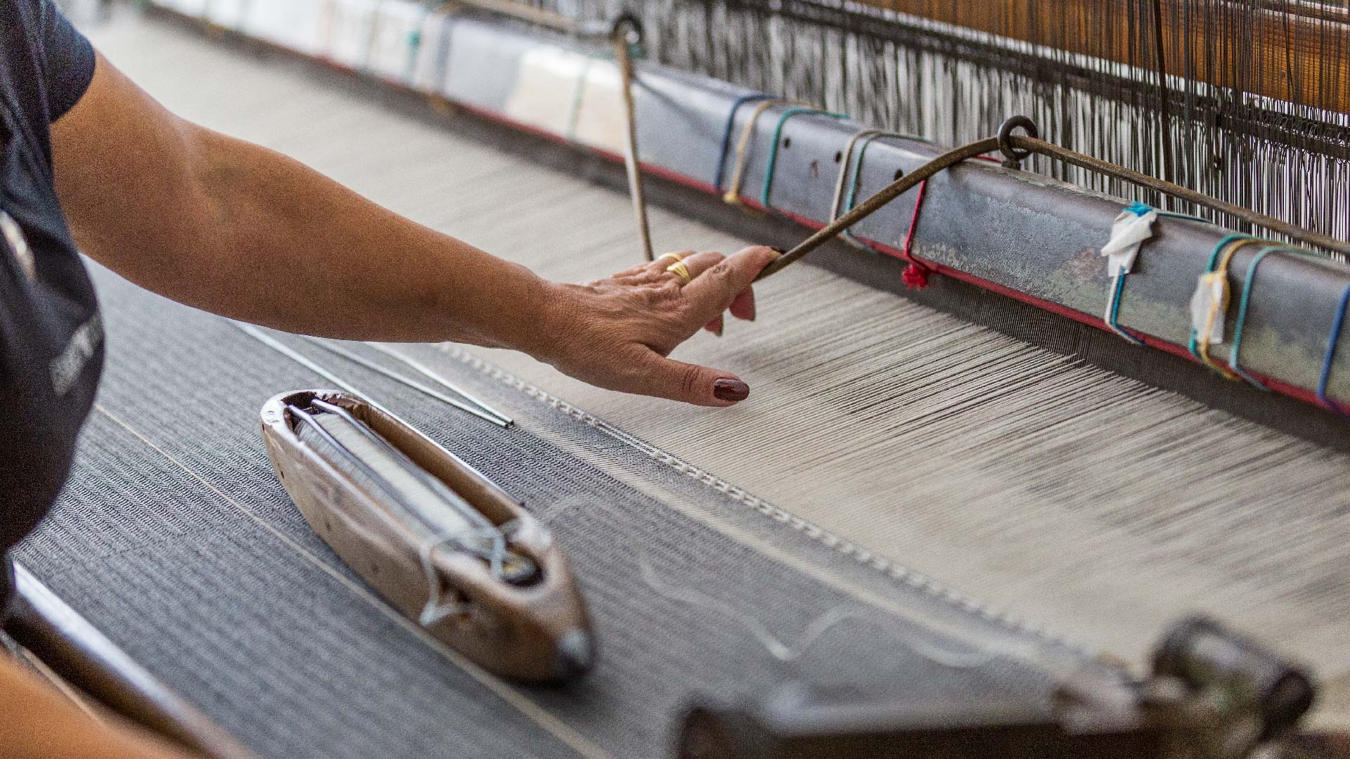 Tessitrice al telaio tradizionale mentre lavora un tappeto in Ogliastra
